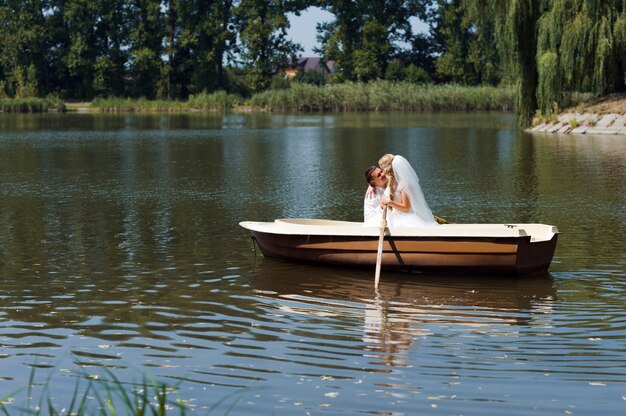 Молодая свадебная пара, плывущая на лодке