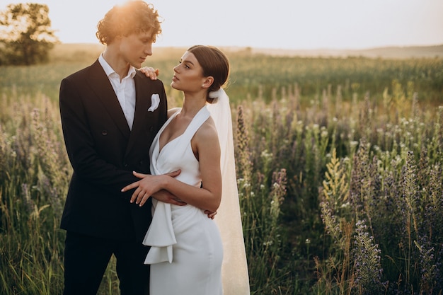 Young wedding couple together in field