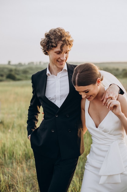 Young wedding couple together in field