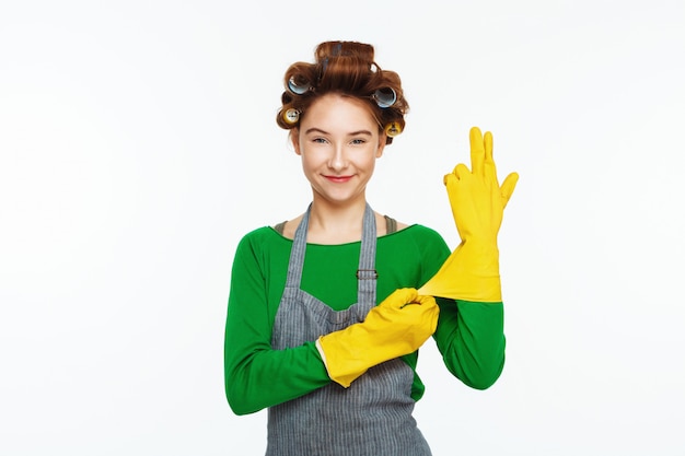 Free photo young white woman wears yeallow rubber gloves and smoles