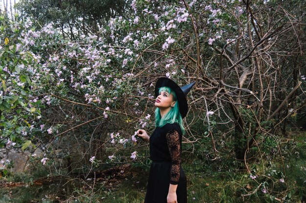 Young witch at blooming tree