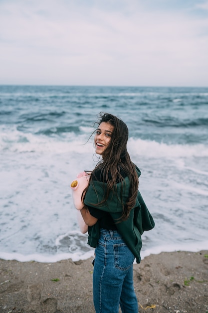 Молодая женщина снимает на смартфон морские волны