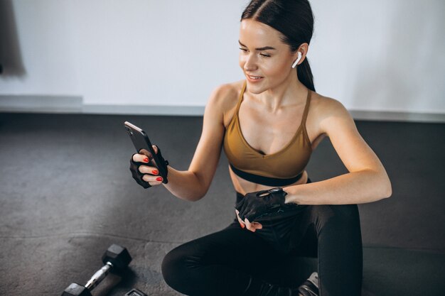 Giovane donna aercising in palestra con manubri