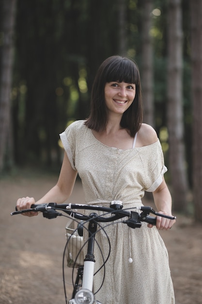 Young woman against nature background with bike