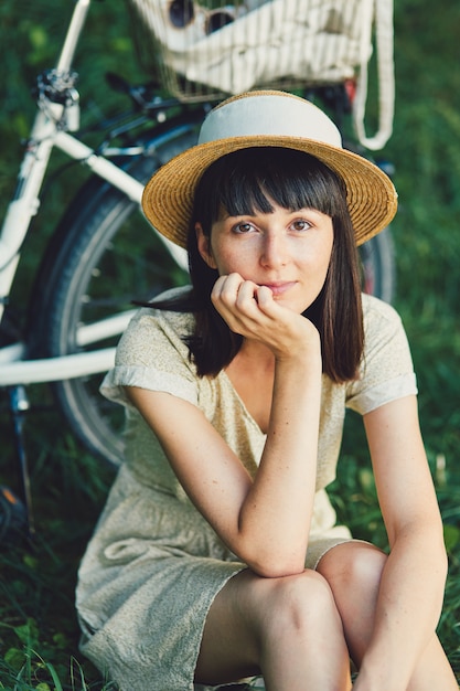 Young woman against nature background with bike