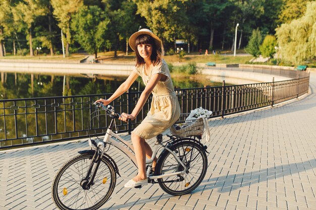 自然の背景に自転車を乗せた若い女性