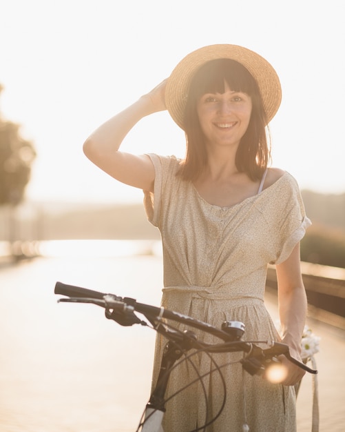 Young woman against nature background with bike