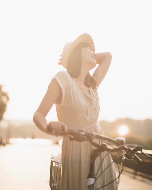 Young woman against nature background with bike