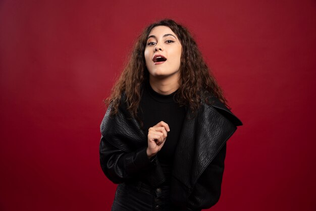 Young woman in all black outfit and makeup.