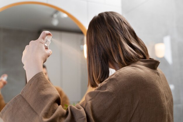 Free photo young woman applying anti dandruff product