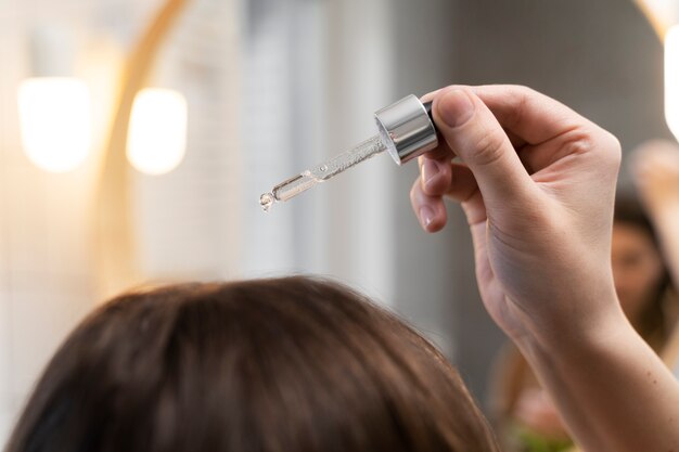 Young woman applying anti dandruff product