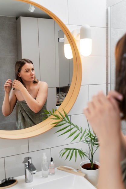 Young woman applying anti dandruff product