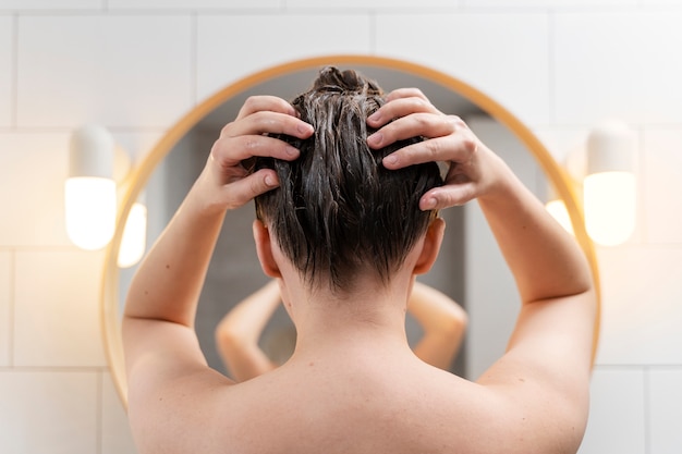 young woman applying anti dandruff product