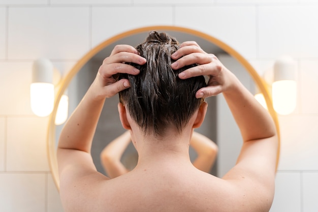 Young woman applying anti dandruff product