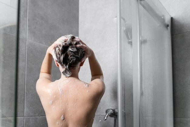 Young woman applying anti dandruff product