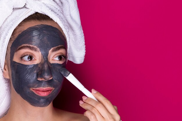 Young woman applying face mask