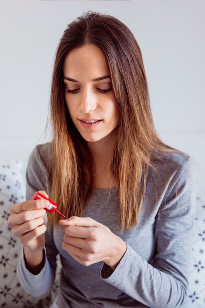 Young woman applying nail polish