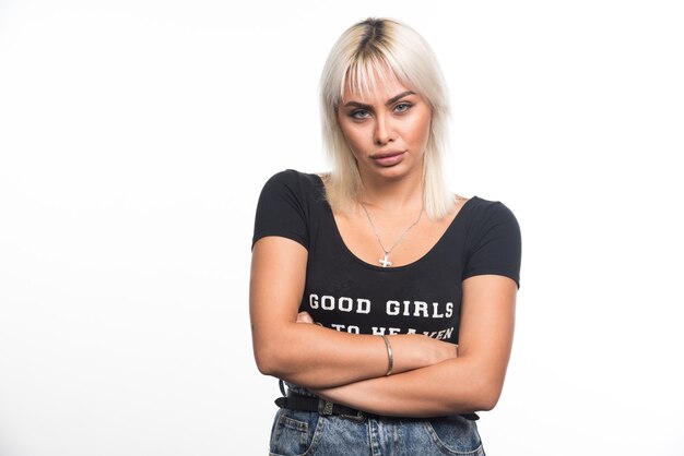 Free photo young woman arms crossed on white wall.