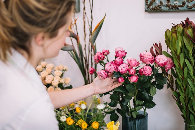 Young woman arranging flowers in shop