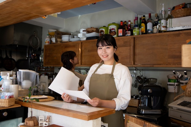 Free photo young woman arranging her cake shop