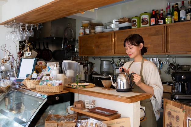 Free photo young woman arranging her cake shop