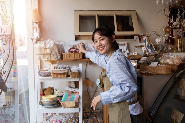 Free photo young woman arranging her cake shop