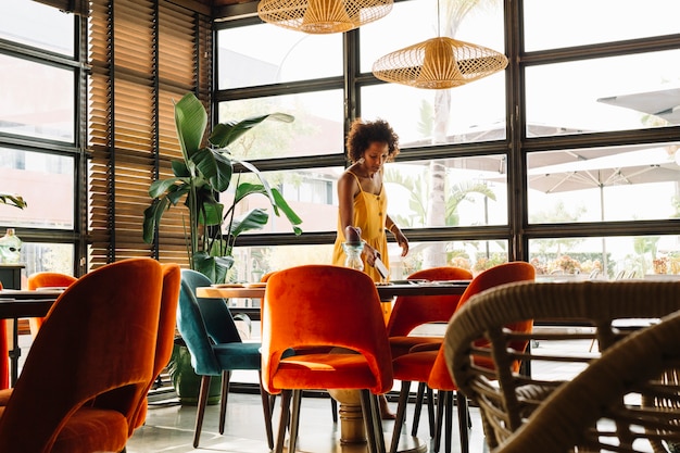 Young woman arranging the table in the restaurant