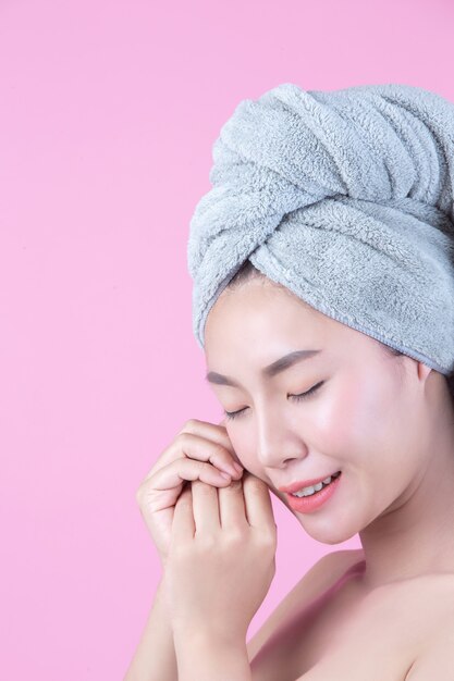 清潔でさわやかな肌を持つ若い女性アジアが自分の顔に触れる