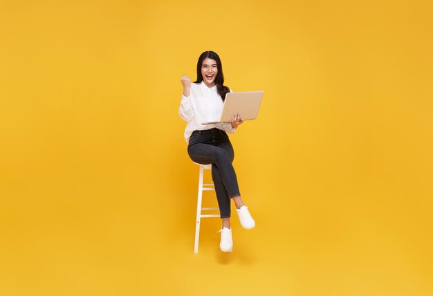 젊은 여자 아시아 행복 미소 그녀는 흰색 의자에 앉아 노트북을 사용하는 동안