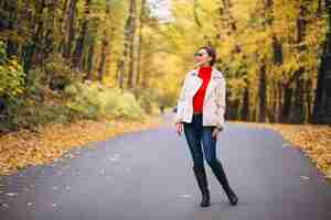 Foto gratuita giovane donna in un parco in autunno