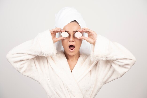 Young woman in a bathrobe doing make-up .