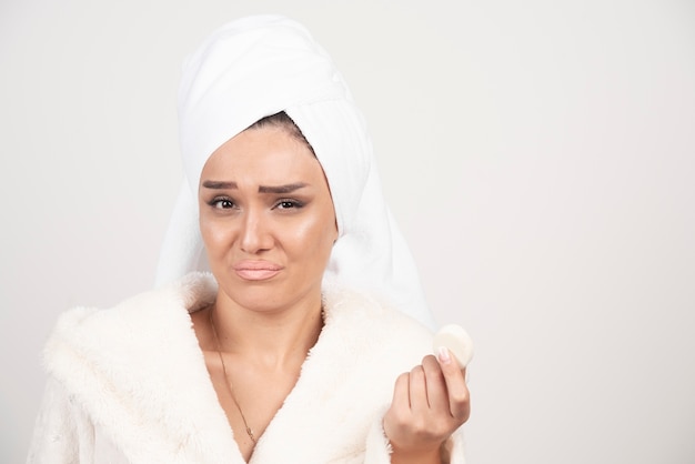 Young woman in a bathrobe doing make-up