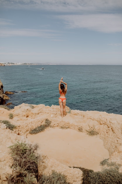 ビーチの空中の美しい海の腕の上のビーチで若い女性