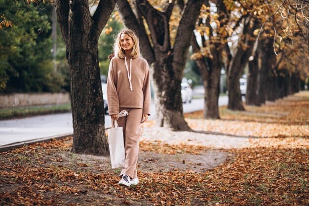 Young woman in beige suit outside in an autumn park