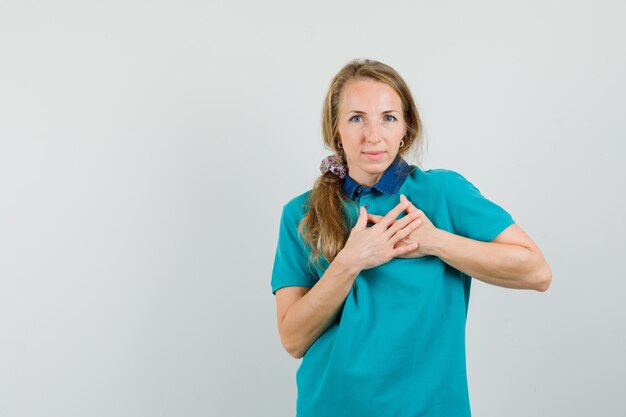 Young woman being pleased compliment or gift in t-shirt and looking grateful. 