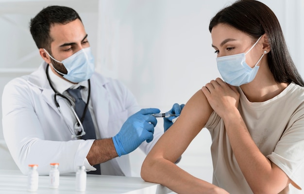 Young woman being vaccinated by doctor Premium Photo