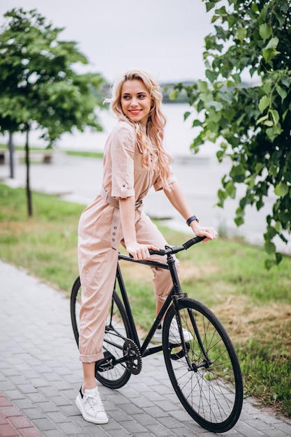 Giovane donna in bicicletta nel parco