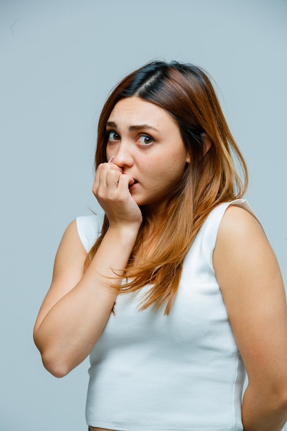 Foto gratuita giovane donna che si mangia le unghie