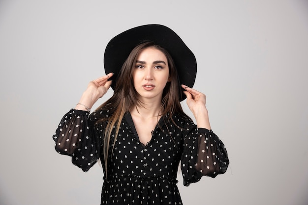 Young woman in black dress looking at camera.