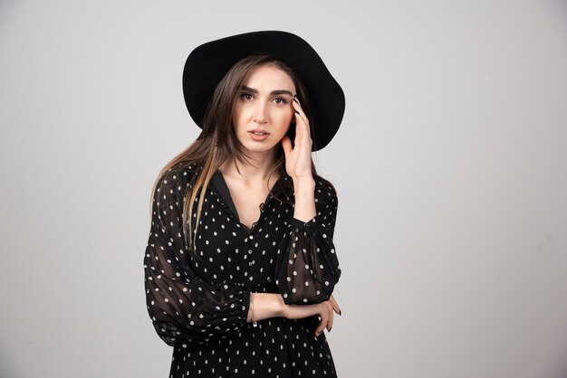 Young woman in black dress looking at camera.