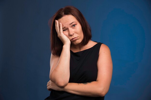 Free photo young woman in black shirt looks bored.