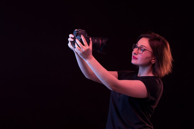 Young woman in black t-shirt with camera