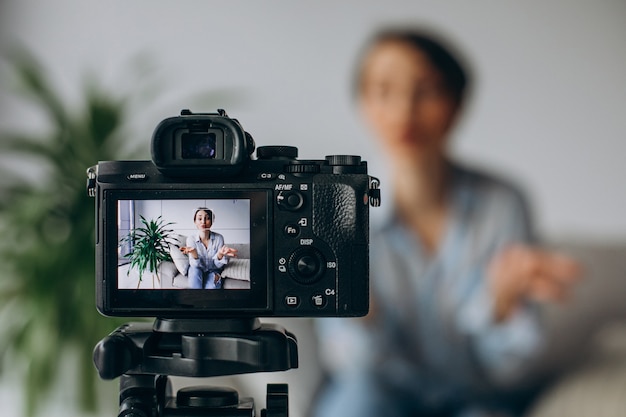 Young woman blogger recording video on camera