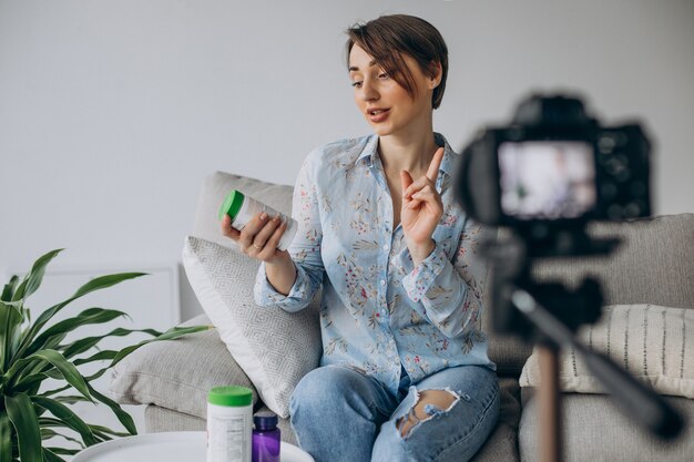 Young woman blogger recording video on camera