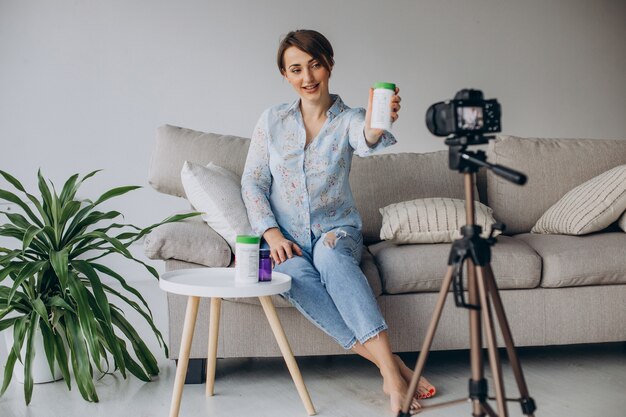 Young woman blogger recording video on camera