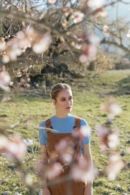 Young woman between blooming branches