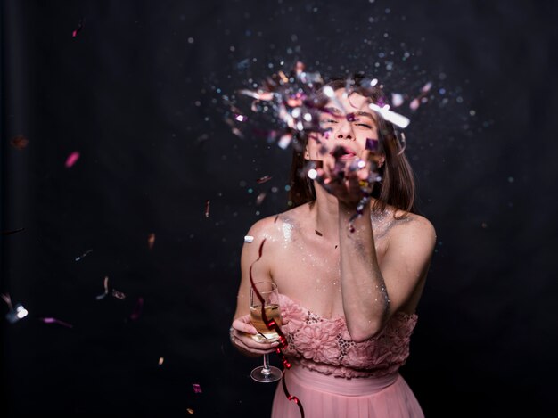 Young woman blowing confetti