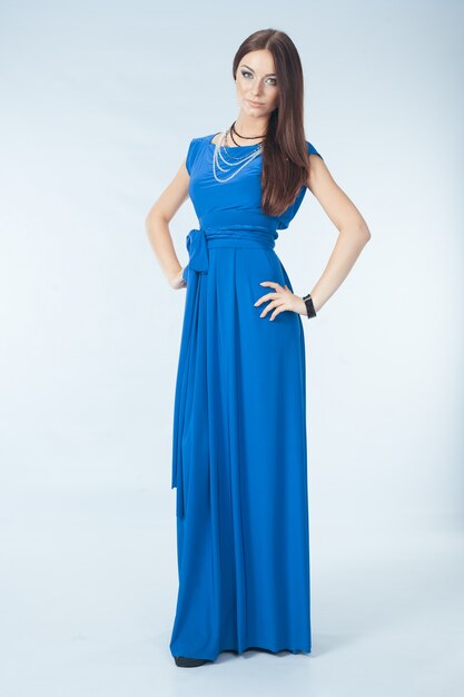 Young woman in blue dress posing in studio