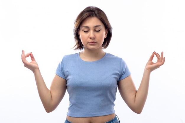 Free photo young woman in blue shirt meditating