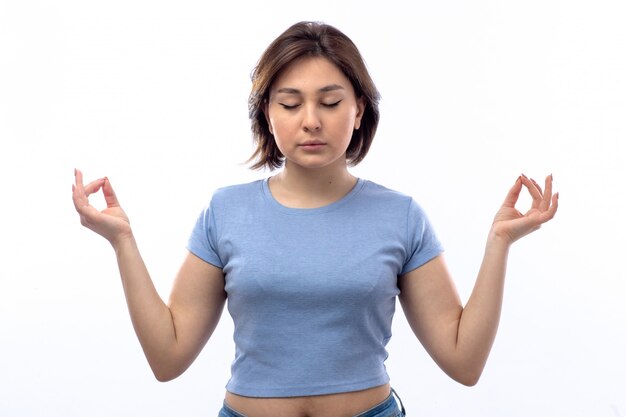 Young woman in blue shirt meditating